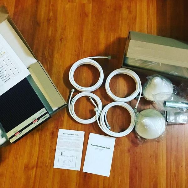 Mobile signal booster unboxed showing the repeater unit, coaxial cables, dome antennas and mounting hardware